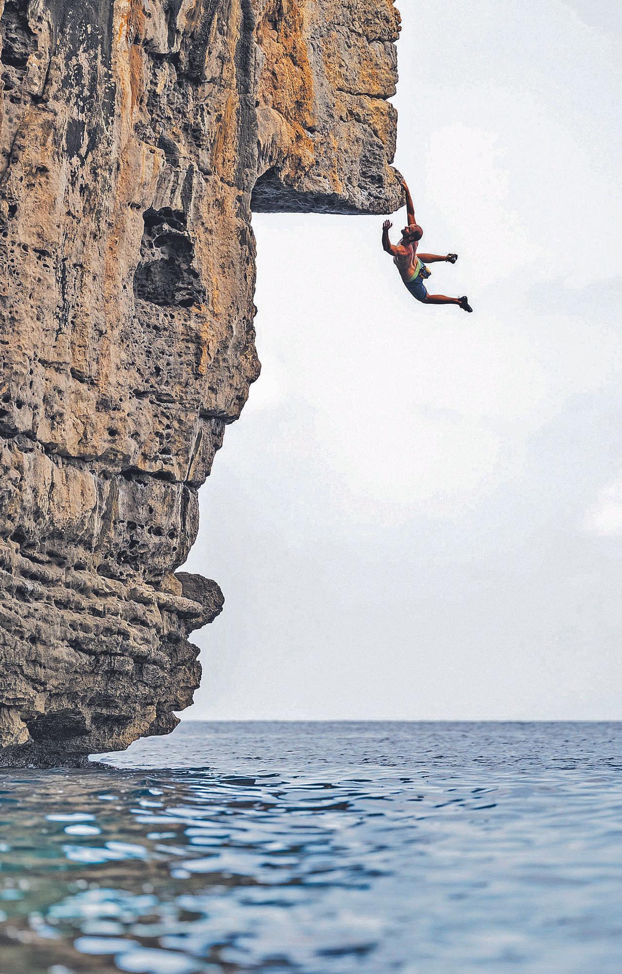 Un escalador practicando psicobloc en una roca de Mallorca. 