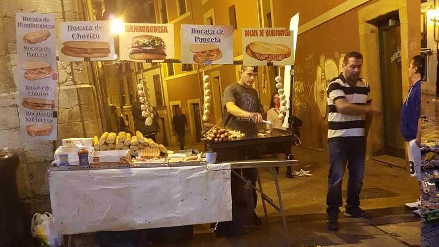 A la izquierda, un puesto ambulante con plancha de gas butano en el Antiguo. A la derecha, la calle Mon.