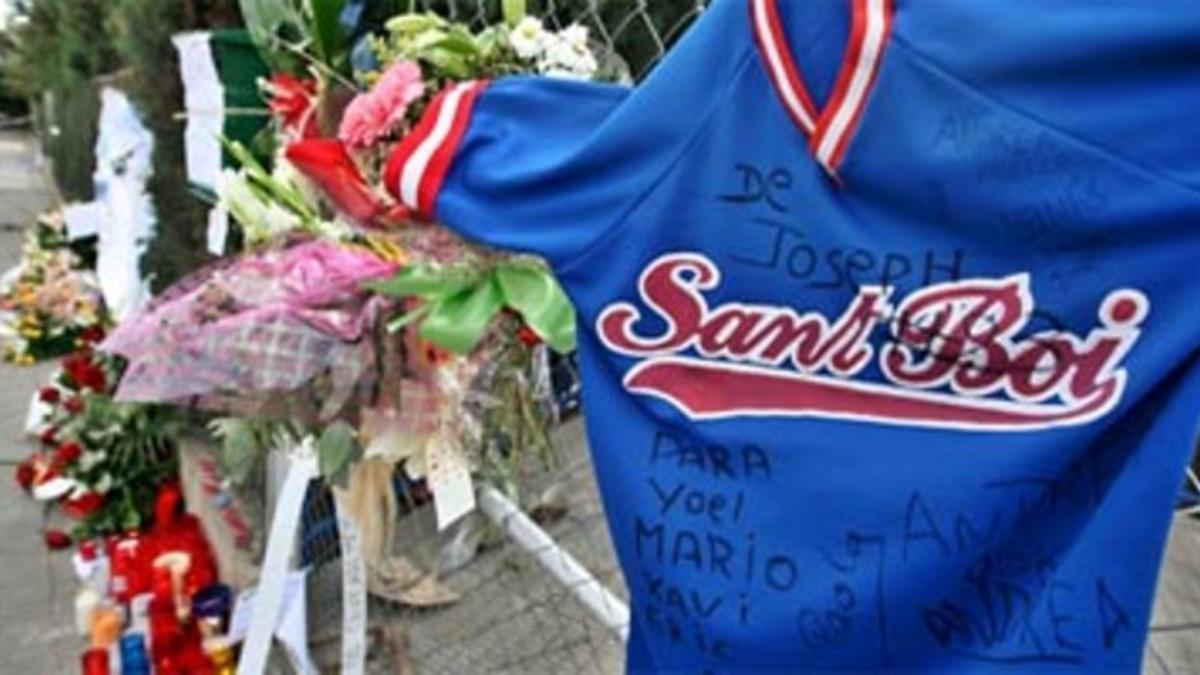 La valla del campo de béisbol de Sant Boi, repleta de objetos en memoria de los cuatro niños fallecidos, esta mañana.