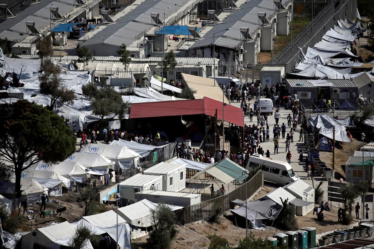 FILE PHOTO - Refugees and migrants line up for food distribution at the Moria migrant camp on the island of Lesbos, Greece October 6, 2016.   REUTERS/Alkis Konstantinidis/File Photo