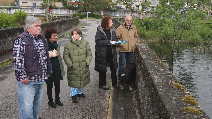 Merche Álvarez con otros vecinos ante el embalse de As Conchas, ayer. | Iñaki Osorio