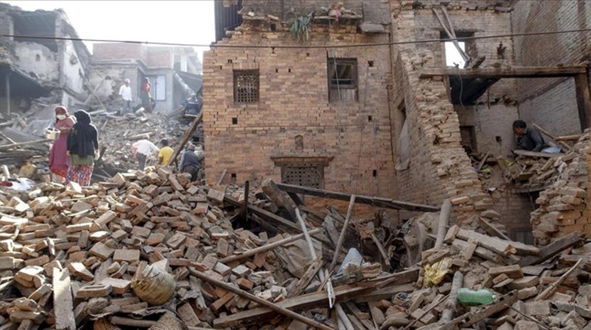 Veïns de Bhaktapur busquen pertinences entre les seves cases destruïdes pel terratrèmol, aquest dilluns.