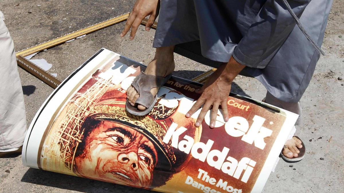 Un hombre pisa la imagen de Gadafi tras su caída a manos de los rebeldes libios.