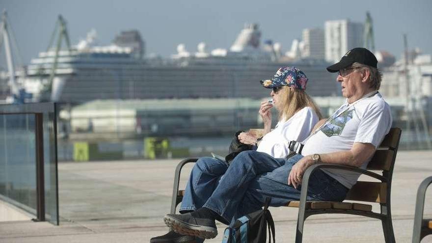 Dos turistas disfrutan del sol, ayer, en el paseo de O Parrote.