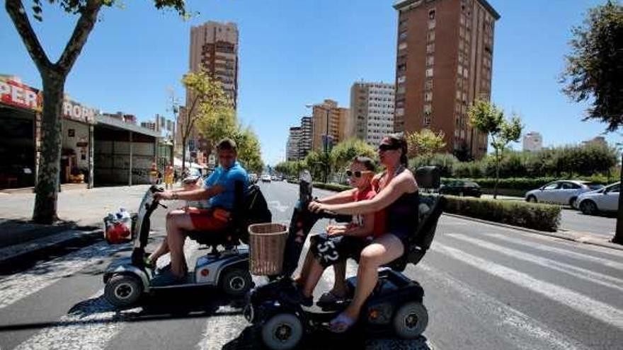 Turistas con dos sillas eléctricas de alquiler en Benidorm.