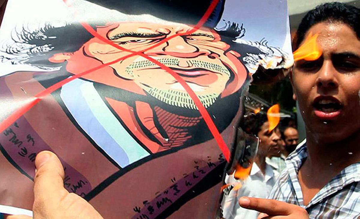 Un ciutadà libi, resident a Malàisia, crema una caricatura de Muammar al-Gaddafi durant una protesta als voltants de l’ambaixada líbia de Kuala Lumpur.