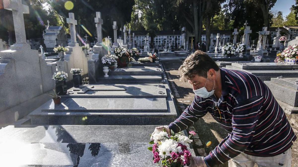 Una persona deposita flores en el cementerio de La Salud.