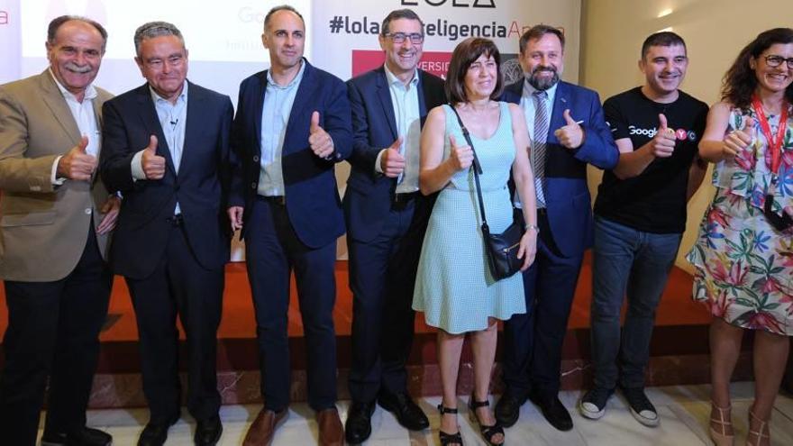 Juan Antonio Campillo, presidente del Consejo Social de la UMU; Andrés Pedreño, exrector de la Universidad de Alicante; Alejandro García, rector de la UPCT; José Luján, rector de la UMU; Lola Ferrer, trabajadora del SIU que da nombre al robot; Pedro Miguel Ruiz, delegado del rector para la Universidad Digital; Andrés Martínez, representante de Google; y María Sesena, vicerrectora de Internacionalización.