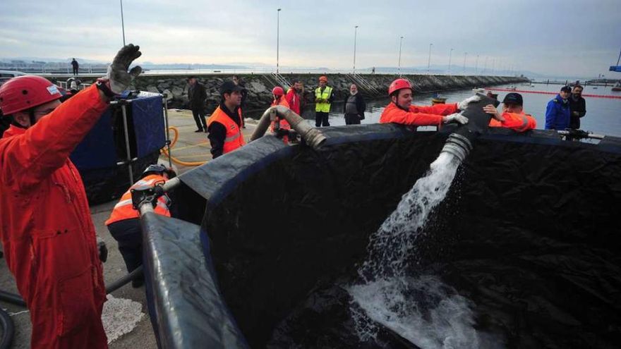 El agua succionada por el &quot;skimmer&quot; se vacía en uno de los depósitos habilitados en el muelle. // Iñaki Abella