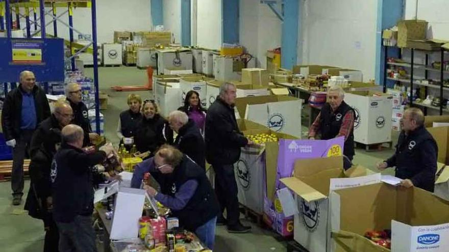 Varios voluntarios organizan los alimentos donados.