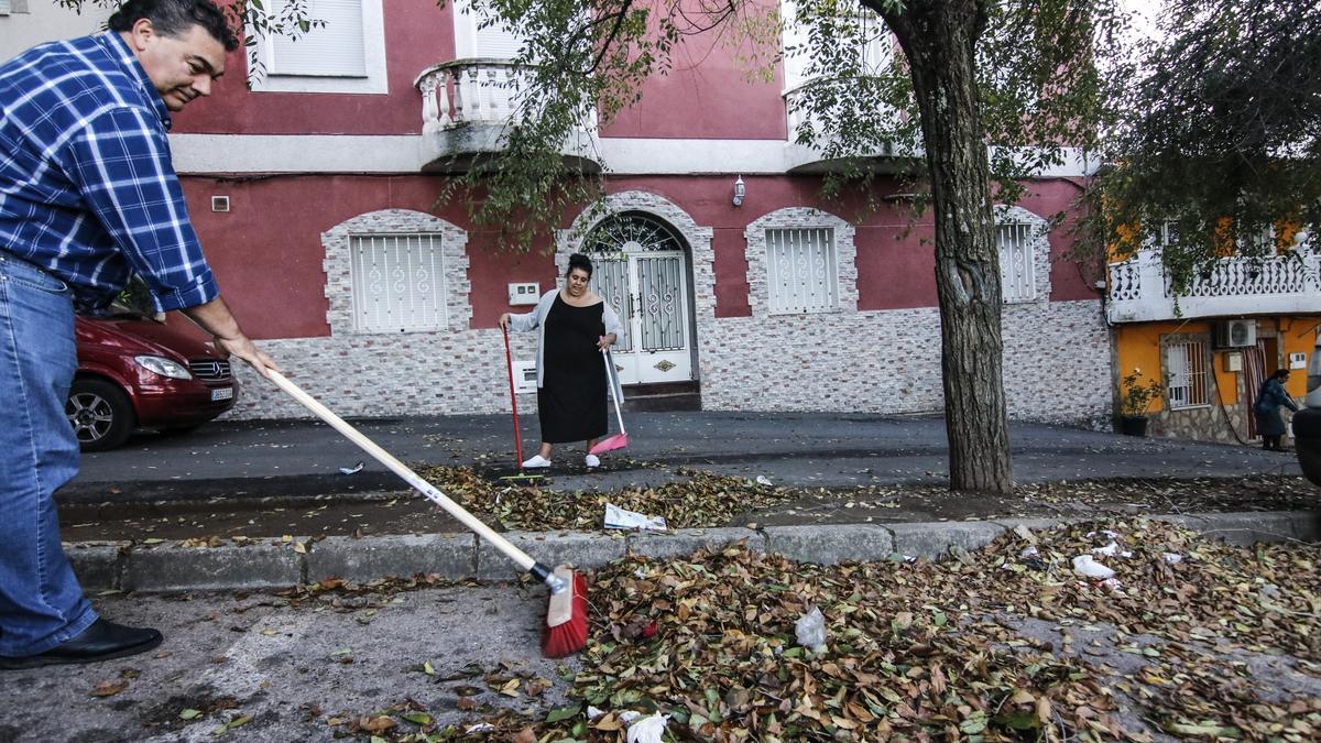 Antonio Molina y su mujer en la calle Jilguero, ayer limpiando en la barriada cacereña de Aldea Moret.