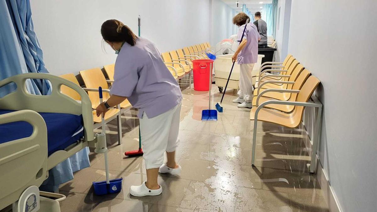 Diverses treballadores de neteja traient l'aigua de la planta -1 de l'hospital de Figueres.