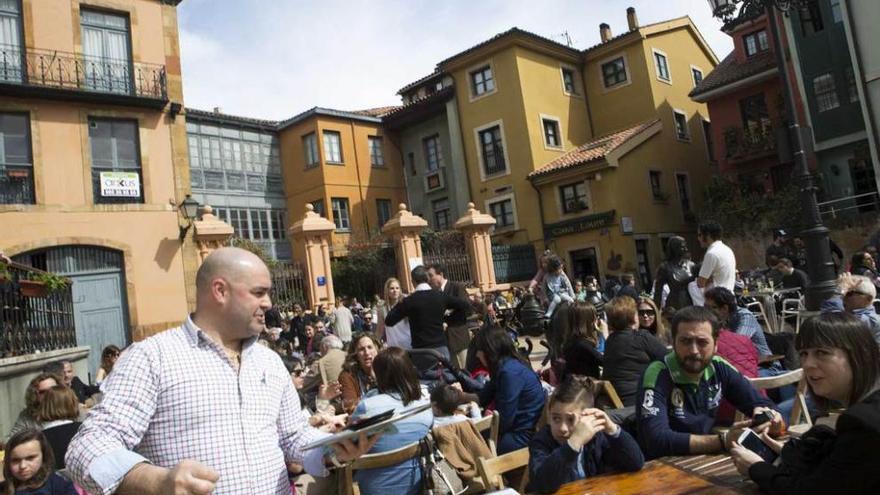 RAMOS Y VERMÚ. Los ovetenses llenaron ayer las terrazas del Antiguo, como la de Trascorrales, a la izquierda, tras la bendición del Domingo de Ramos, en la Catedral a la derecha.