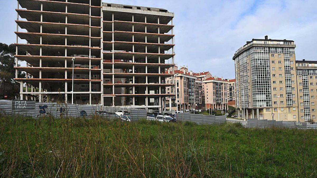 En primer término, solar municipal en Os Rosales junto a un edificio que paró su construcción.   | // C. PARDELLAS