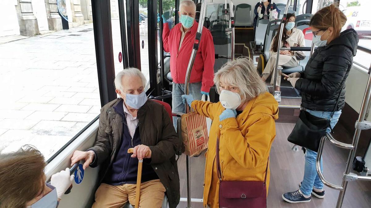 Pasajeros de Vitrasa con mascarilla tras decretarse su uso obligatorio en el transporte público. // Marta G. Brea