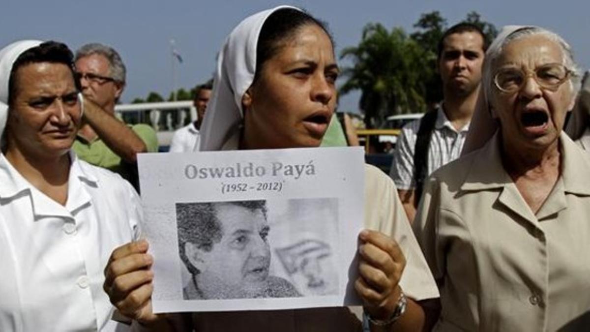 Unas religiosas muestran la fotografía de Paya el martes pasado durante el entierro del disidente cubano en La Habana