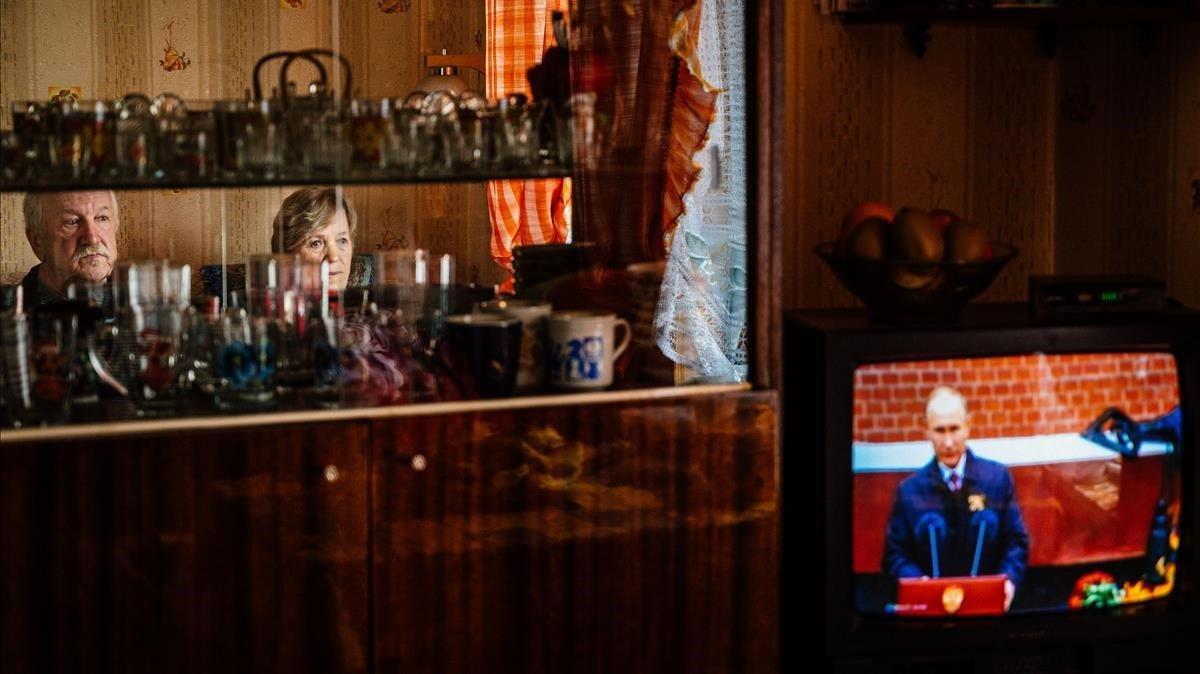 Gennady Matveiev y su esposa Galina miran la pantalla de televisión durante un discurso del presidente ruso Vladimir Putin