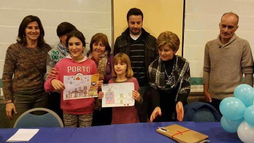 Arriba, Nora Fernández (izquierda) e Inés Arias, con la alcaldesa, concejales y miembros de la organización. Abajo, los niños dibujando.