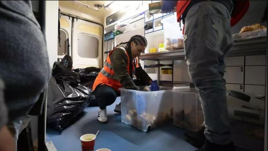 Una voluntaria de Cruz Roja prepara una de las bolsas de alimentos dentro del furgón.