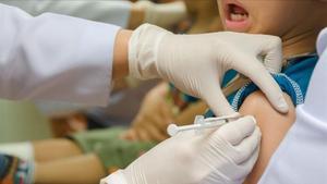 Una enfermera pone una vacuna a un niño.