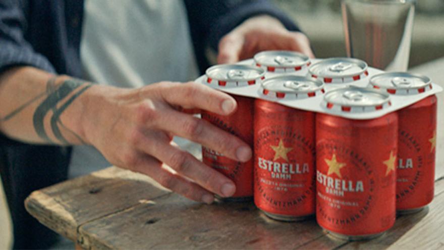 Estrella Damm comenzará a sustituir las anillas de plástico de sus latas por otras de cartón 100% biodegradable.