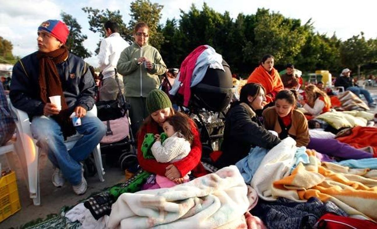 Una família espera per tornar a casa seva després de passar la nit al carrer per por de les rèpliques del terratrèmol.