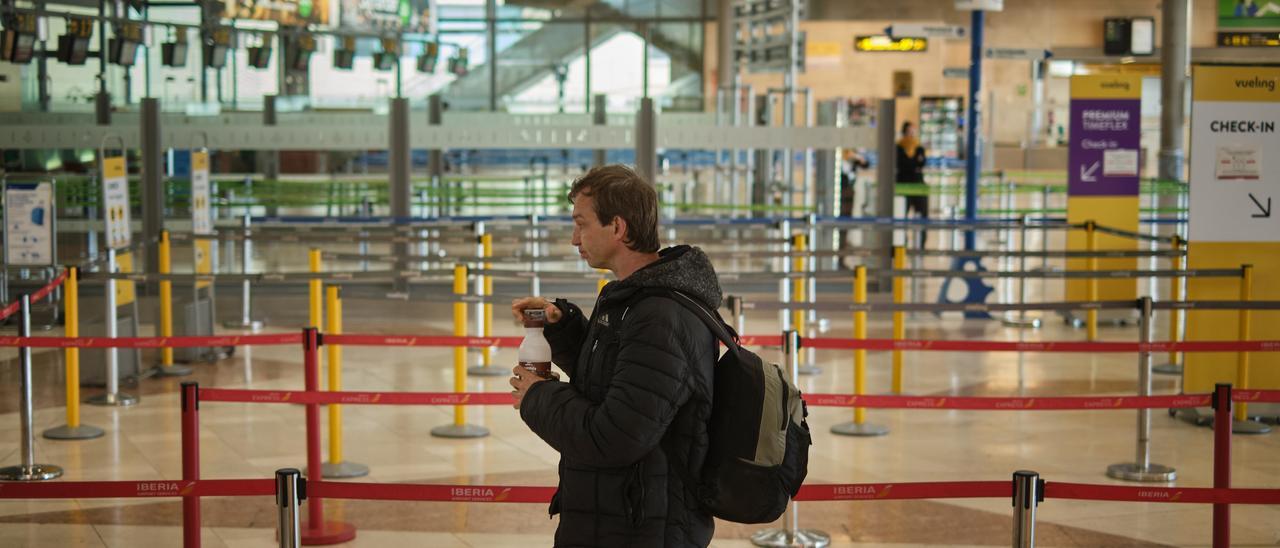 La caída de los turistas se traduce en menor recaudación; en la imagen, un viajero en el aeropuerto, vacío, de Los Rodeos.