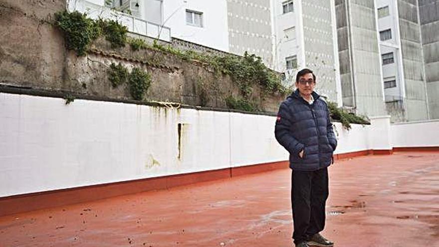 Ladero, en el patio trasero de su edificio, con un inmueble y un solar en ruinas a su espalda.