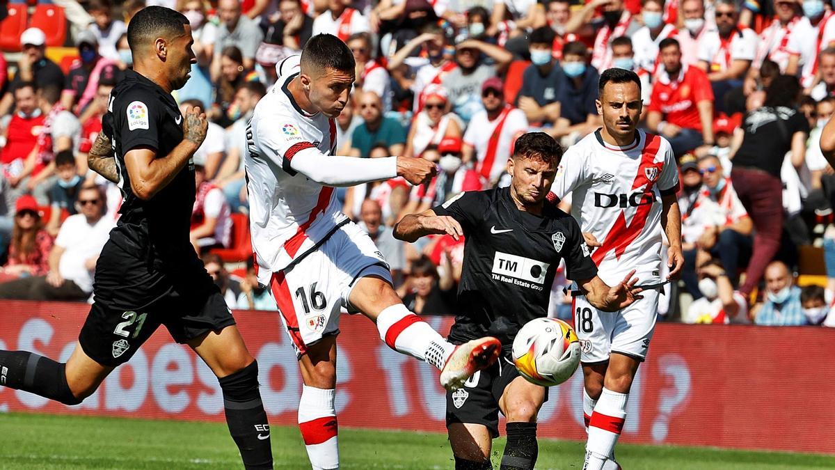 El delantero del Rayo Vallecano Sergi Guardiola dispara a portería ante la oposición de Pablo Piatti y de Omar Mascarell.  | J.J. GUILLÉN