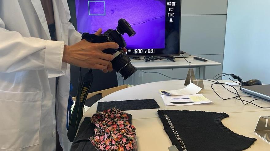 Un agent de la Policia Científica utilitzant la càmera 'Full spectrum' per comprovar les taques de sang en una samarreta