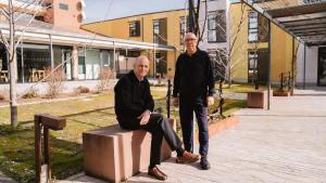 Luis y Pepe, miembros de la Comisión de Comunicación de Trabensol y vecinos de este coliving senior de Torremocha del Jarama, posan en el patio del agua.