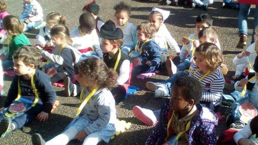 Arriba, los pequeños de la escuela Gloria Fuertes junto al grupo &quot;L&#039;Enguedeyu&quot;. A la izquierda, un campeonato de pulsos en el &quot;Gedo&quot;.