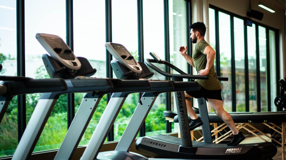 Un hombre corriendo en la cinta de correr en un gimnasio