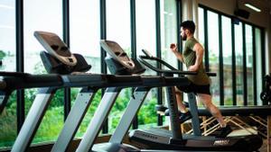 Un hombre corriendo en la cinta de correr en un gimnasio.