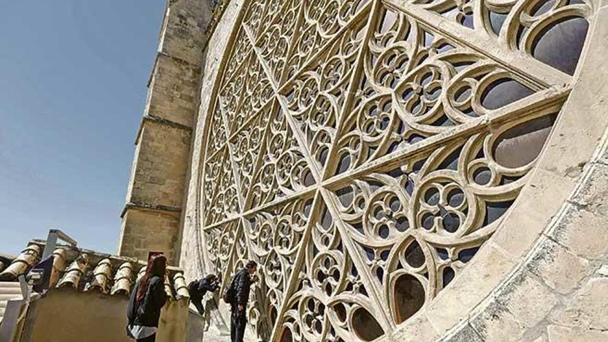 Visitantes de las terrazas de la Seu comprobando de cerca las dimensiones del rosetón mayor del templo.