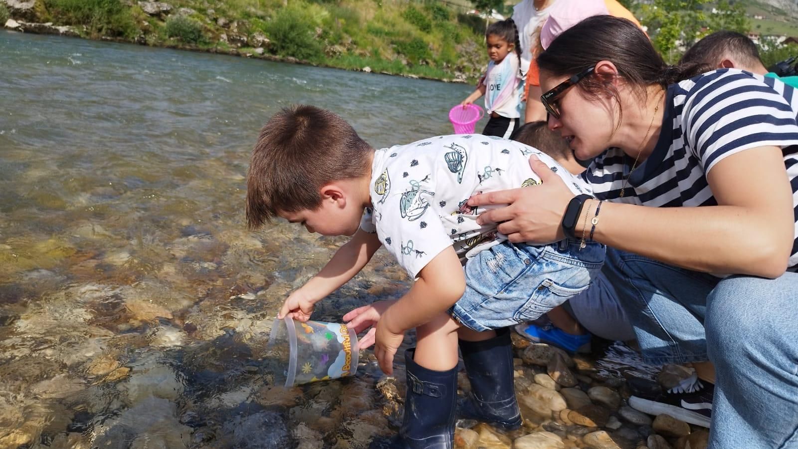 Los escolares de Arriondas repueblan el Sella con 5.000 alevines de trucha