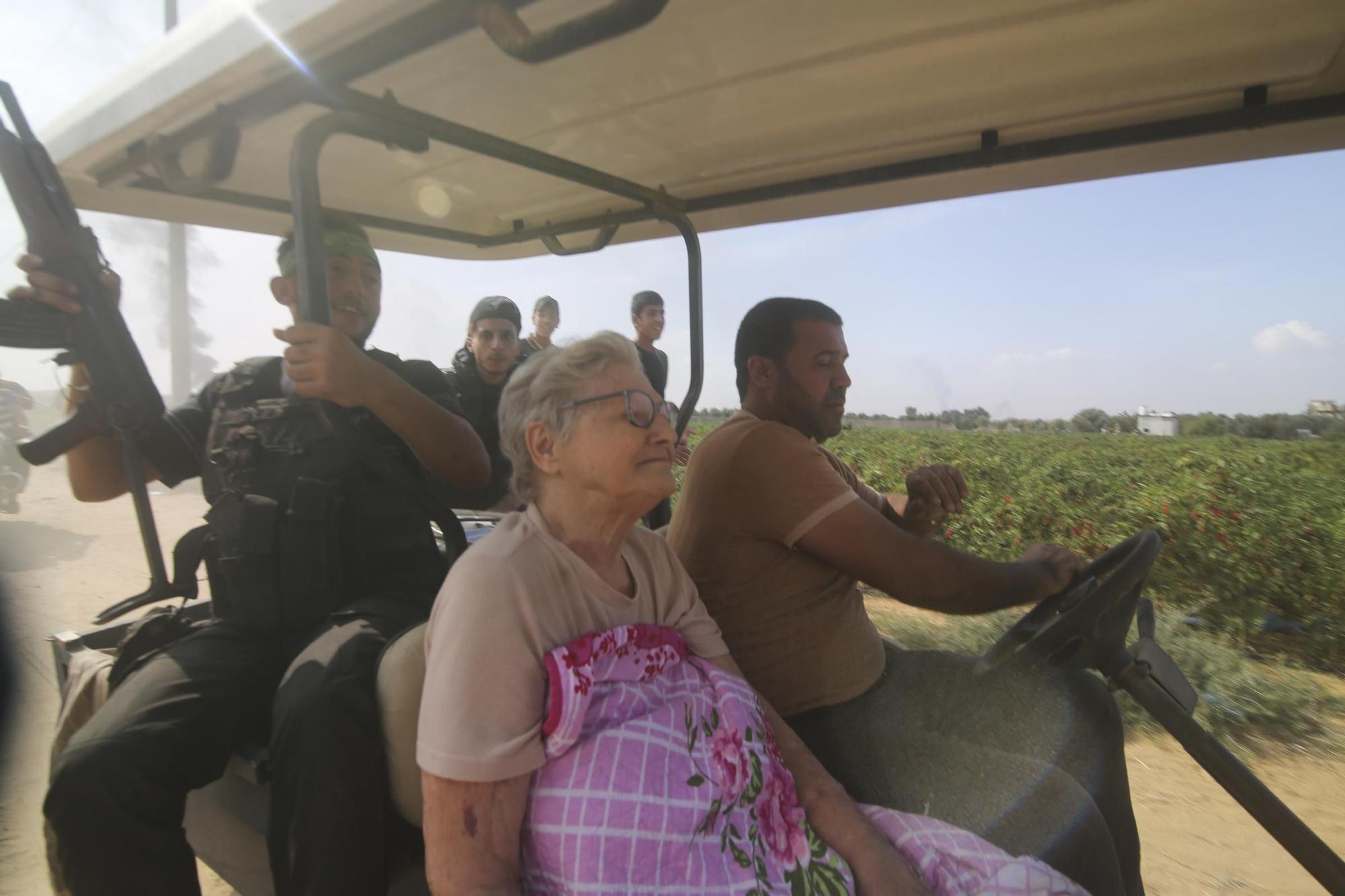 Palestinos transportan a un civil israelí capturado (en el centro), desde Kfar Azza, en el sur de Israel, hacia la Franja de Gaza.