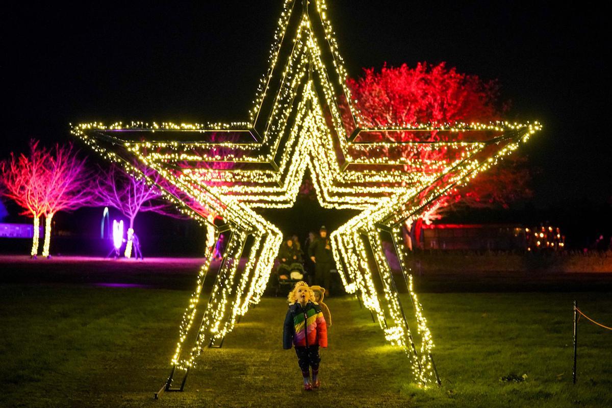 Navidad en Inglaterra, un niño explora un sendero de luces en Malvern.