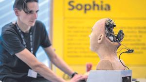 Un técnico trabaja en la cabeza de un robot humanoide en una feria en Ginebra