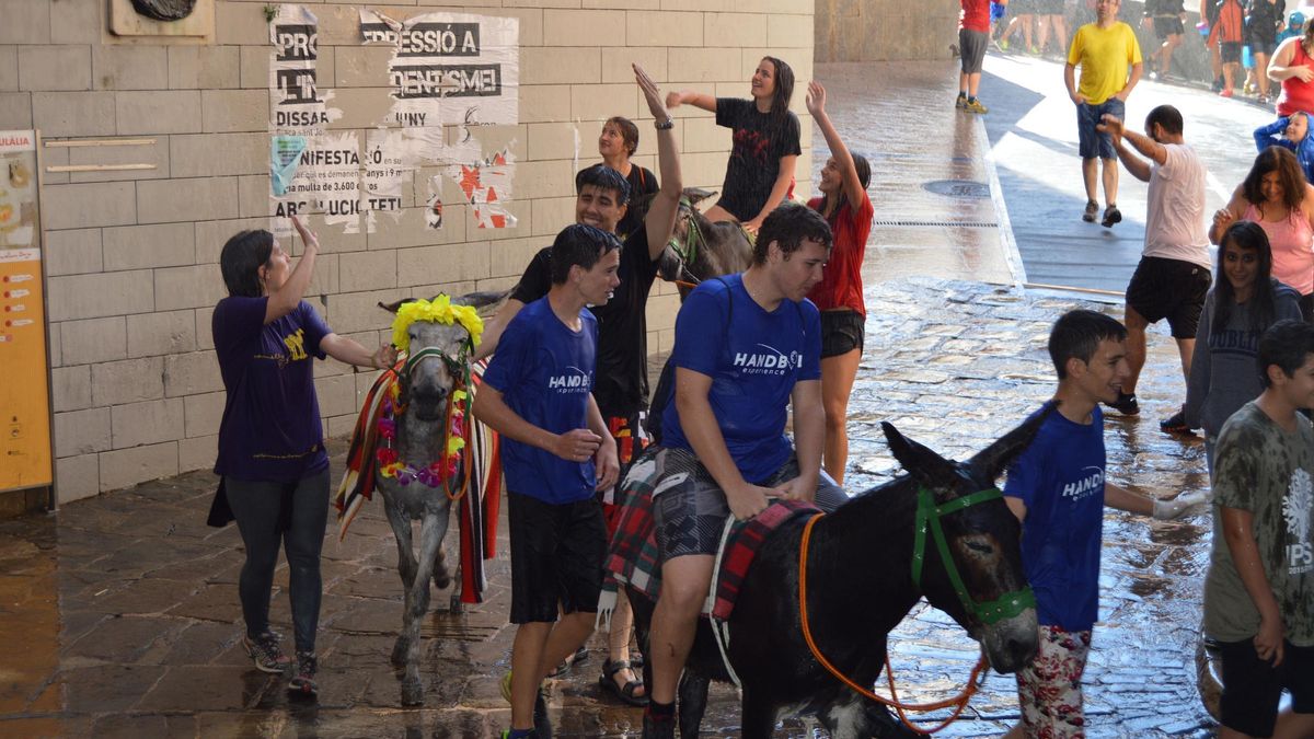 Festa els Elois 2016. Passada de rucs i cavalls pels carrers de Berga. Els berguedans tiren aigua als participants des dels balcons i finestres.