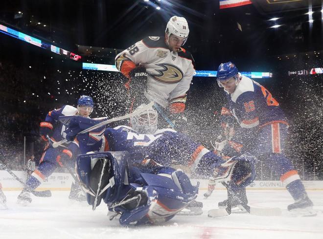 Robin Lehner # 40 de los New York Islanders lucha contra Derek Grant # 38 de los Anaheim Ducks en busca del disco, en el NYCB Live en el Nassau Veterans Memorial Coliseum.