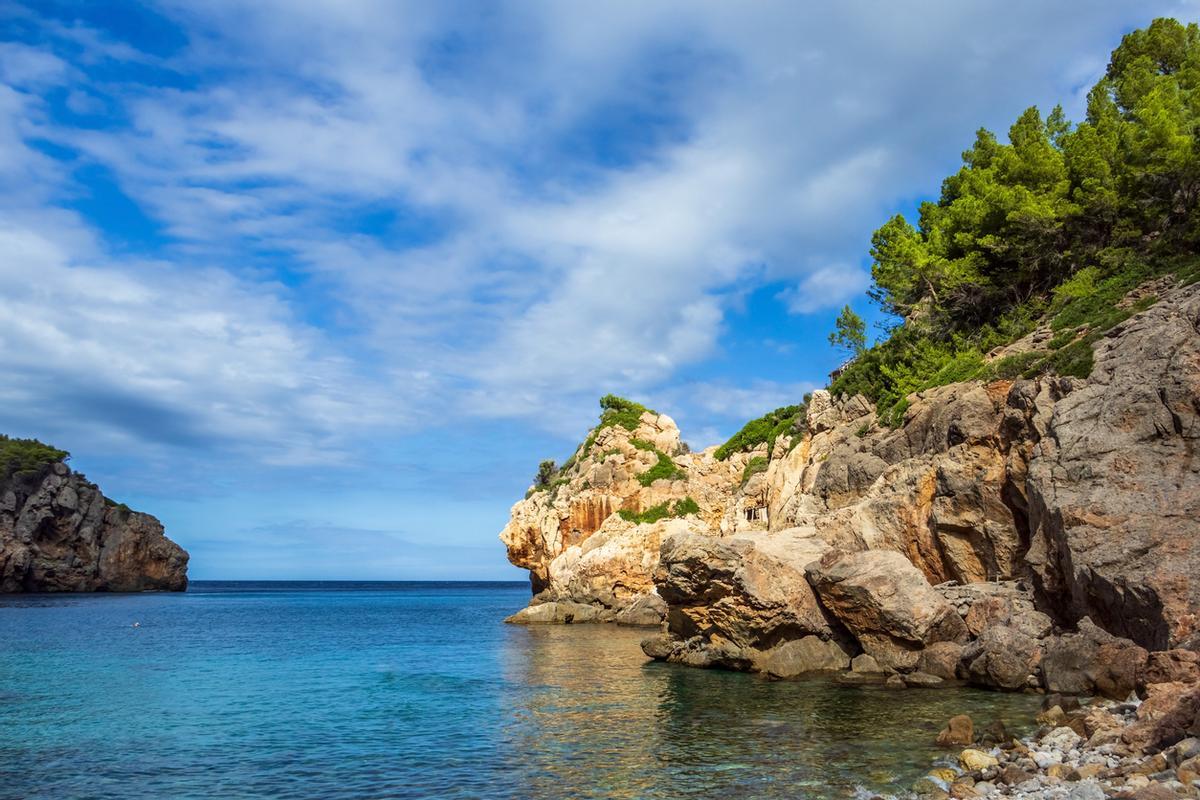 Vista de la playa de Deya Cove en un día soleado en el pueblo de Deia, Islas Baleares, España