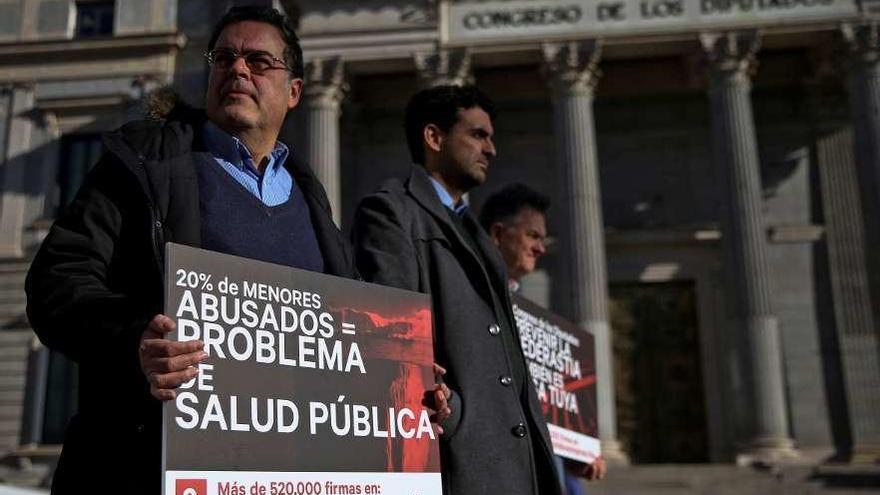 Representantes de las víctimas, ayer, frente al Congreso de los Diputados.