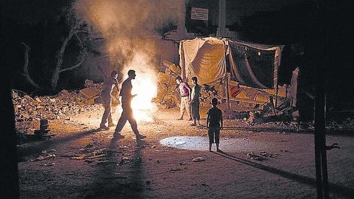 Destrozos 8 Unos palestinos, frente a su casa destruida en Gaza.