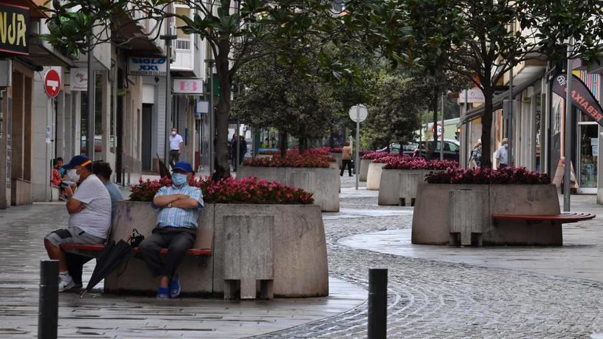 Personas con mascarilla en una calle de Arteixo.