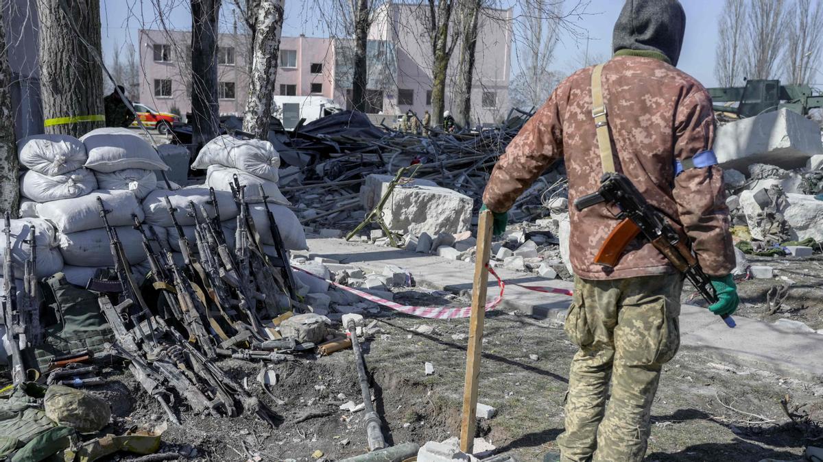 Un soldado ucraniano junto a los rifles de soldados muertos tras el ataque a una escuela militar en Mykolaiv