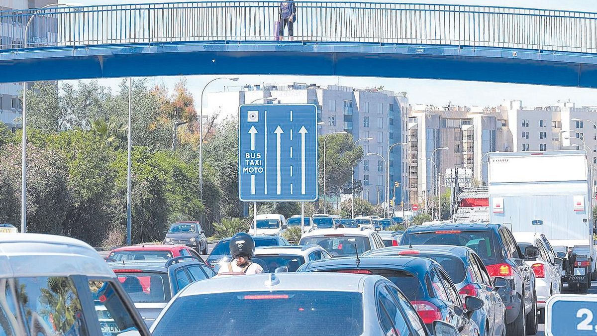 Una mujer mira desde el puente  del Molinar el atasco en la entrada de Palma por la autopista del aeropuerto.