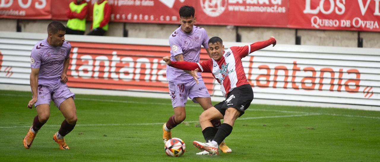 La defensa del Pontevedra se impone a un atacante rojiblanco.