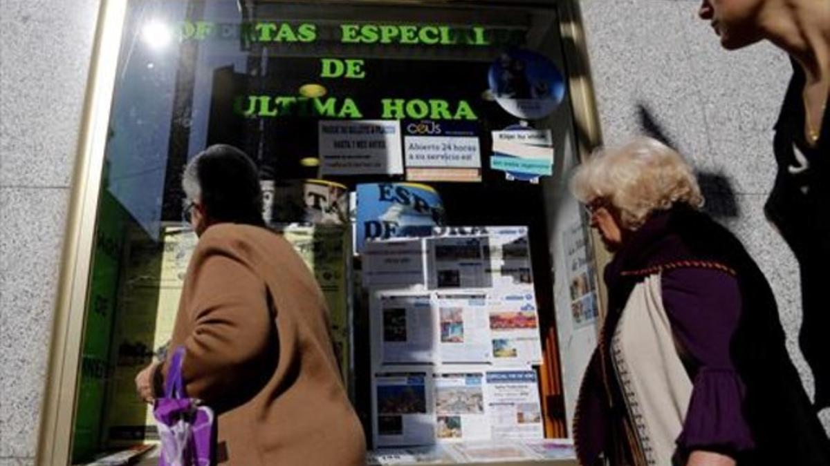 Ofertas 8 Varias mujeres miran el escaparate de una agencia de viajes, en Madrid.
