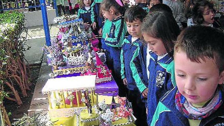 Los niños del Colegio Virgen de Begoña contemplan algunos de los tronos que ellos mismos han construido